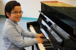 Odric (9 Jahre) am neuen Klavier
